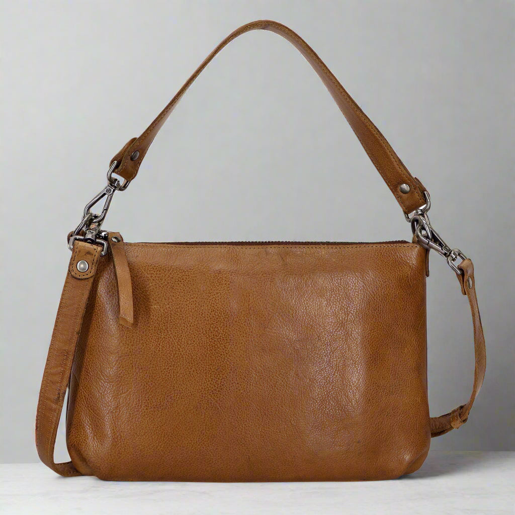 Brown leather handbag with a shoulder strap on a white background