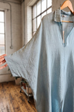 Light blue shirt on a hanger with a blurred indoor background
