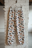 Pajama pants with dog pattern hanging on a brick wall.
