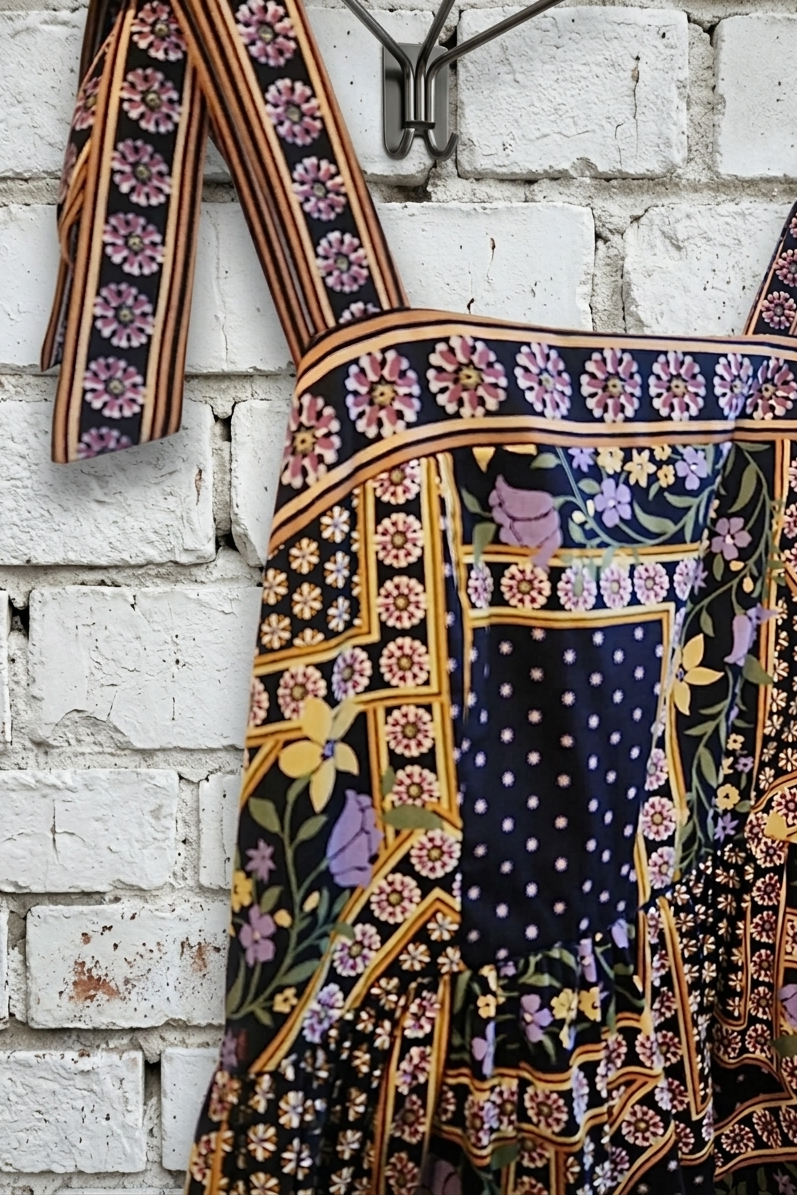 Colorful patterned dress hanging against a white brick wall