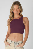 Woman wearing an eggplant-colored crop top against a plain background