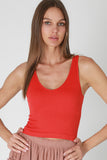Woman wearing a red tank top and pink skirt on a white background