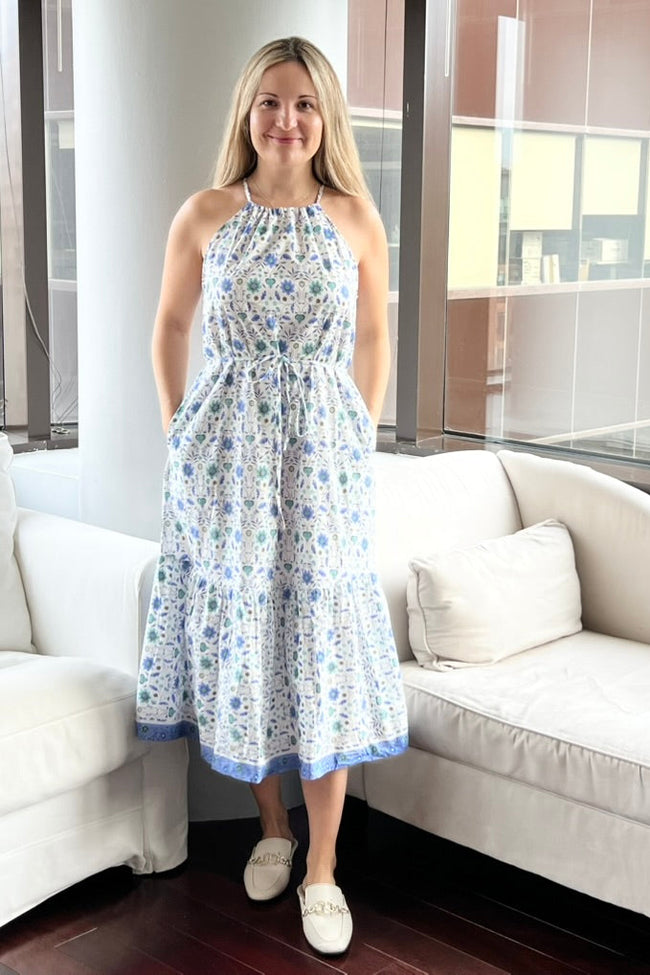 Woman wearing a floral dress standing in a modern living room.
