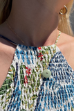 Close-up of a person wearing a colorful patterned top with a button detail.