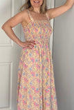 Woman wearing a floral dress standing in a room with white walls and a door.