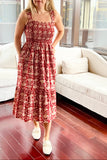 Woman in a red floral dress standing in a modern living room.