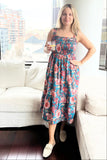 Woman in a floral dress standing in a modern living room.