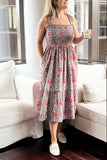Woman in a floral dress standing in a living room with white furniture.
