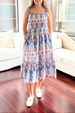 Woman in a floral dress standing in a modern living room.