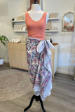 Mannequin wearing a pink top and patterned sarong in a store setting