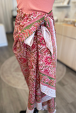 Person wearing a pink floral sarong in an indoor setting