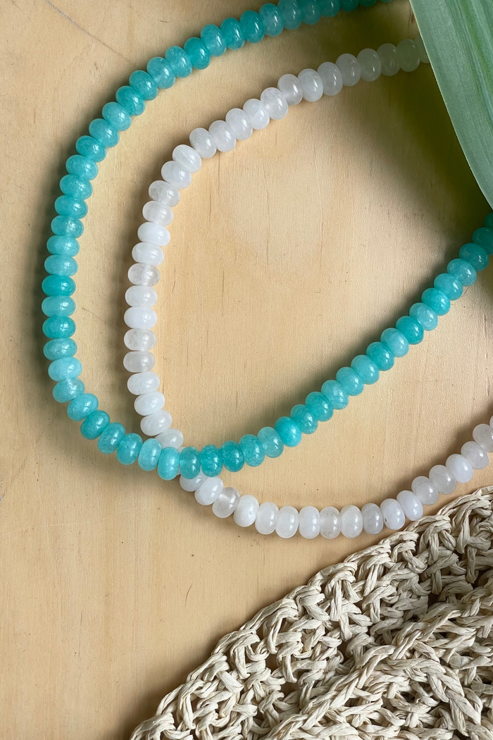 Necklace with blue and white beads on a wooden surface