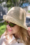 Woman wearing a straw hat and sunglasses outdoors