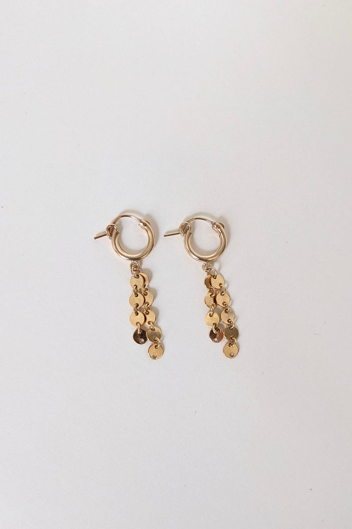 Gold earrings with sequin details on a white background