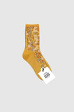 Mustard yellow floral-patterned sock with a brand tag on a white background