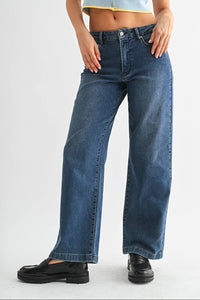 Person wearing blue jeans and a light blue top on a white background