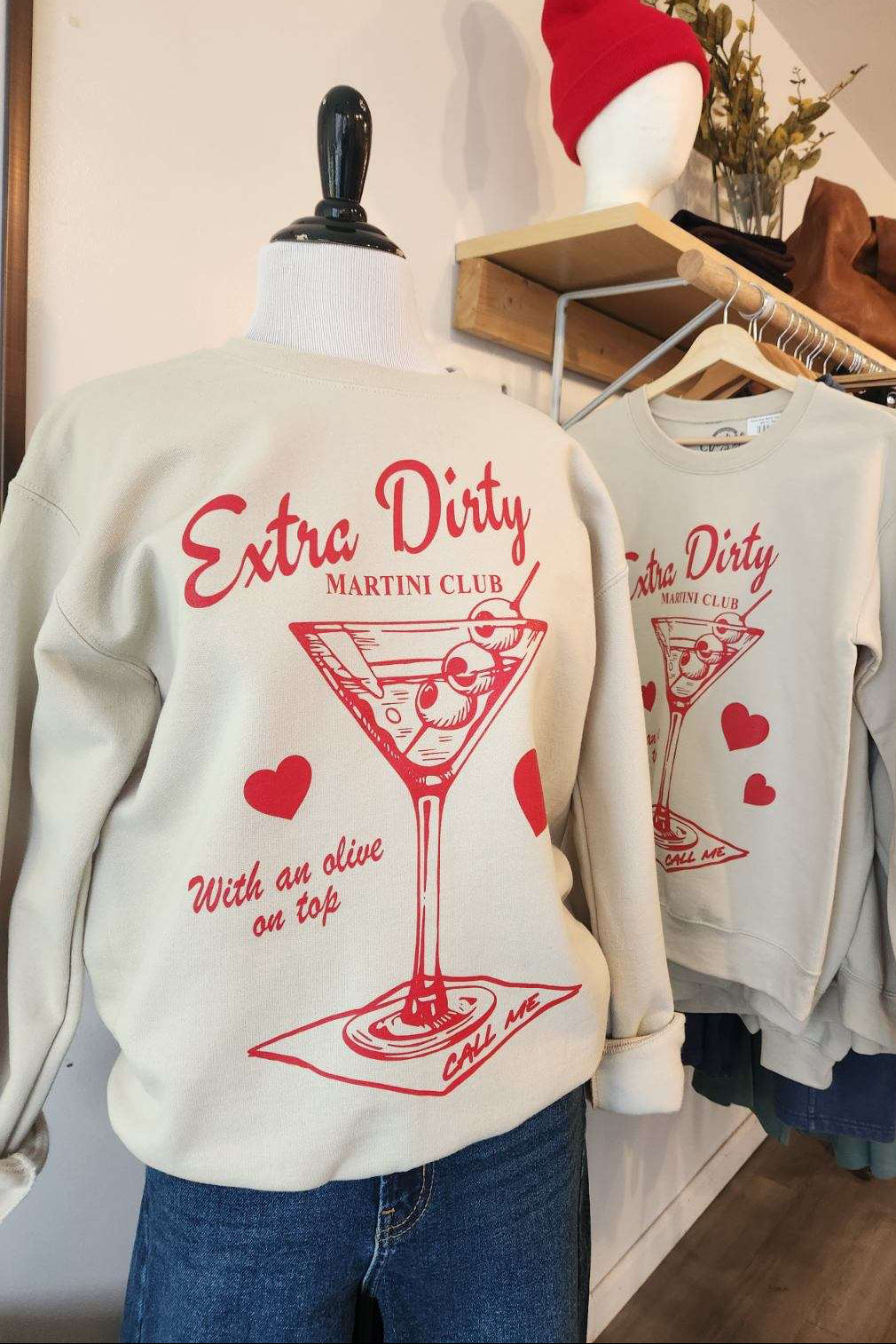 Sweatshirt with 'Extra Dirty' design on a mannequin in a store setting.
