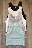 Stack of various tank tops on a wooden surface