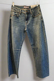 Pair of blue jeans hanging on a rack against a white background