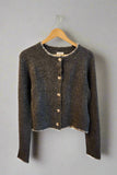 Dark gray textured cardigan with white trim on a hanger against a light background