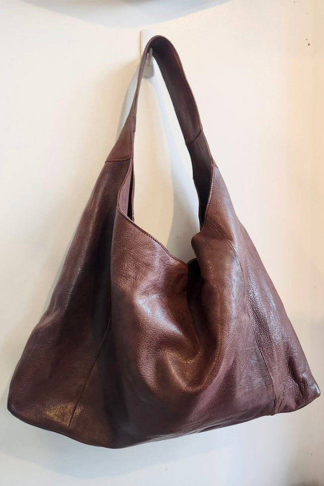 Brown leather handbag on a light beige background