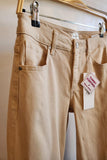 Beige pants on a hanger with a tag labeled 'Tummy Control'.