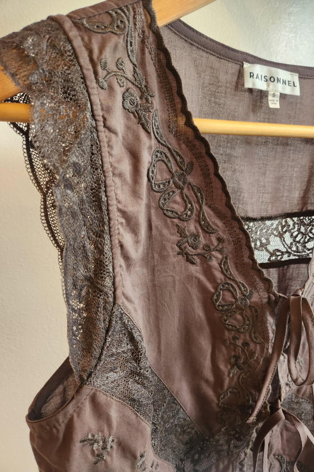 Brown lace lingerie set on a hanger with 'Raisènè' label.