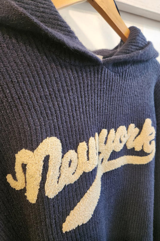 Navy blue sweater with 'New York' text on a hanger