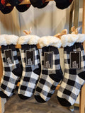 Black and white checkered socks with fluffy tops on a rack, featuring 'Local Color NYC' labels.