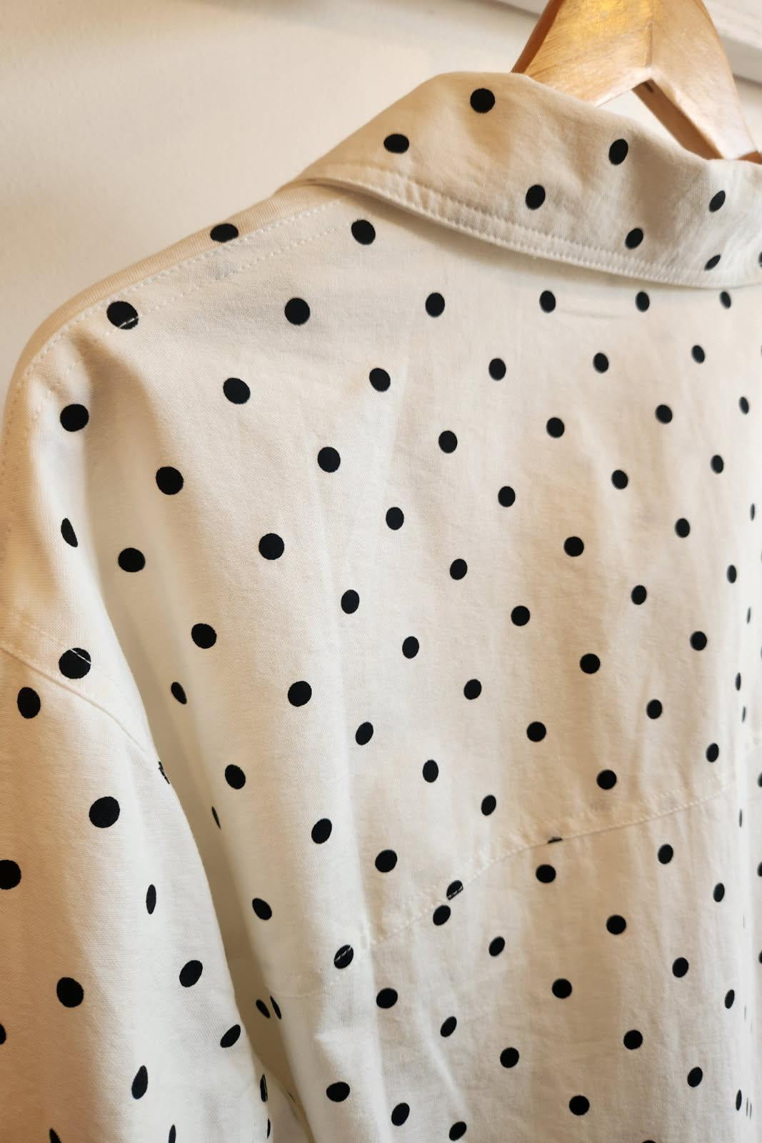 White shirt with black polka dots on a hanger