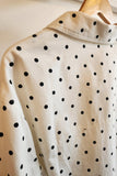 White shirt with black polka dots on a hanger