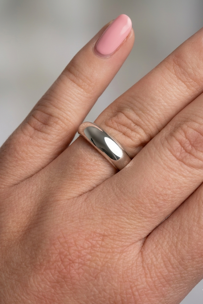 Silver ring on a person's finger with a blurred background