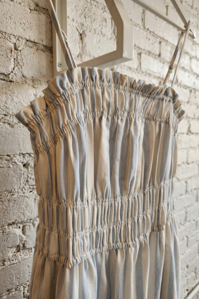 Striped dress on a hanger against a brick wall